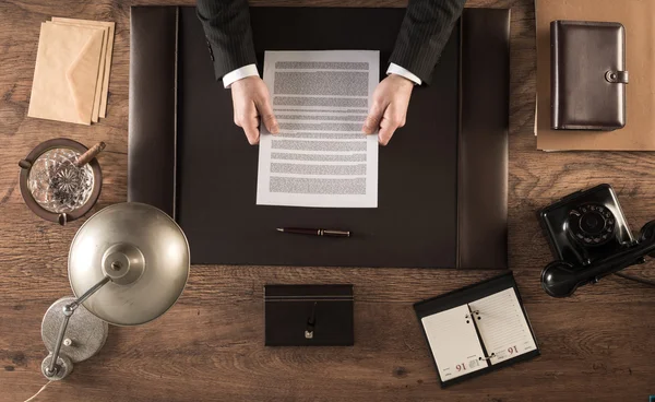 Empresário no escritório lendo um contrato — Fotografia de Stock