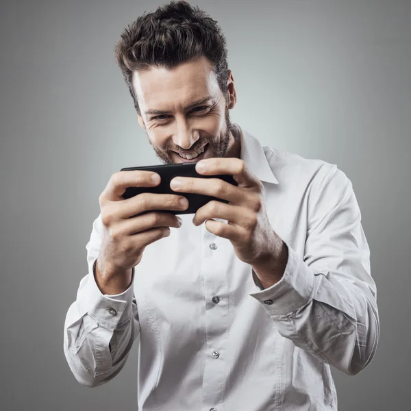 Homem jogando com smartphone — Fotografia de Stock