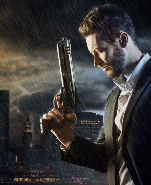 agent under pouring rain holding a gun