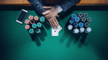 poker oyuncusu ile iki as tutan smartphone