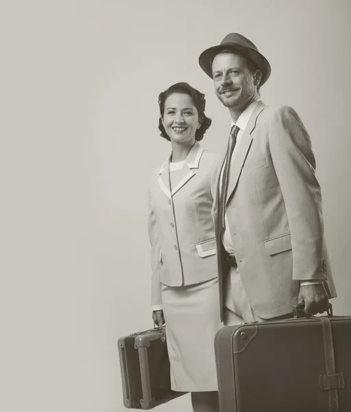Elegante pareja saliendo con el equipaje — Foto de Stock