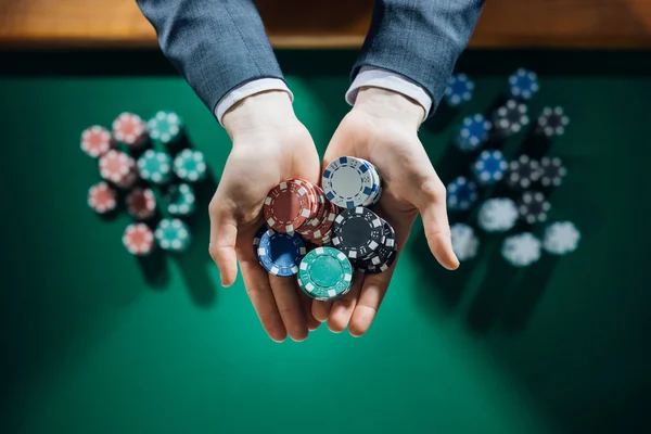 Casino juega sosteniendo un puñado de fichas — Foto de Stock