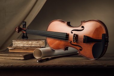 Old violin with music sheet rolls clipart