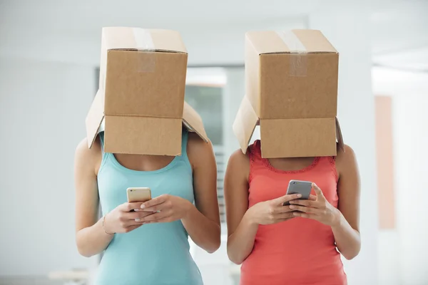 Chicas con cajas en la cabeza mensajes de texto — Foto de Stock