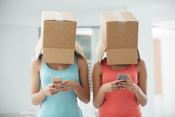 Девушки с коробками на голове пишут смс
