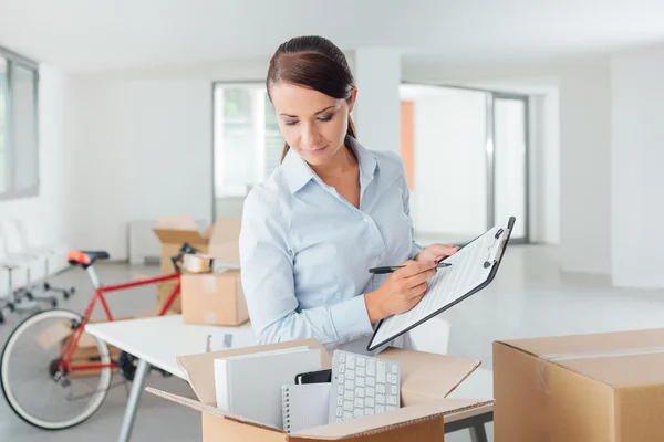 Business woman writing a relocation checklist — стоковое фото