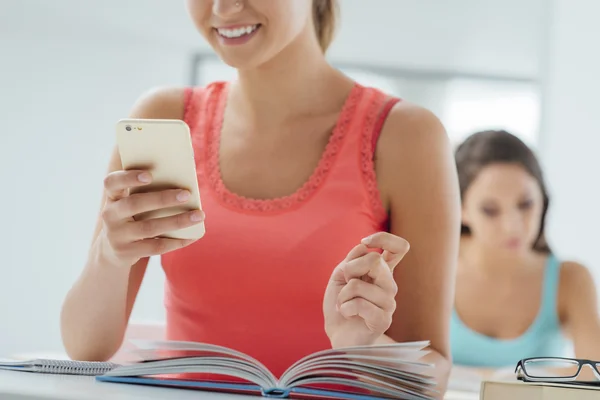 Adolescente usando celular na sala de aula — Fotografia de Stock