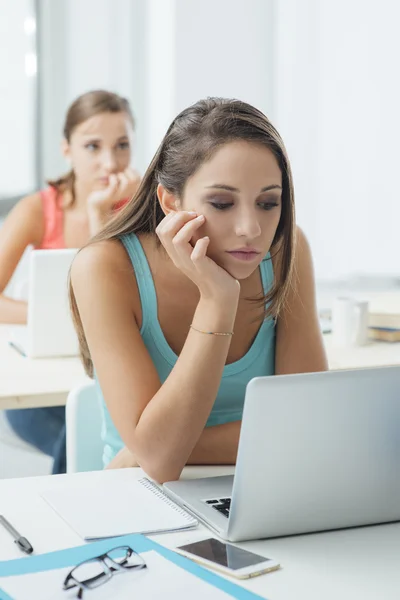 Chica aburrida sentada en el escritorio de la escuela — Foto de Stock