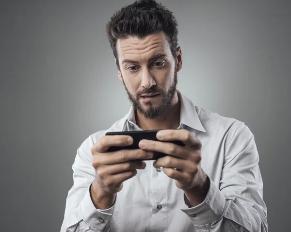 Hombre jugando con su smartphone —  Fotos de Stock