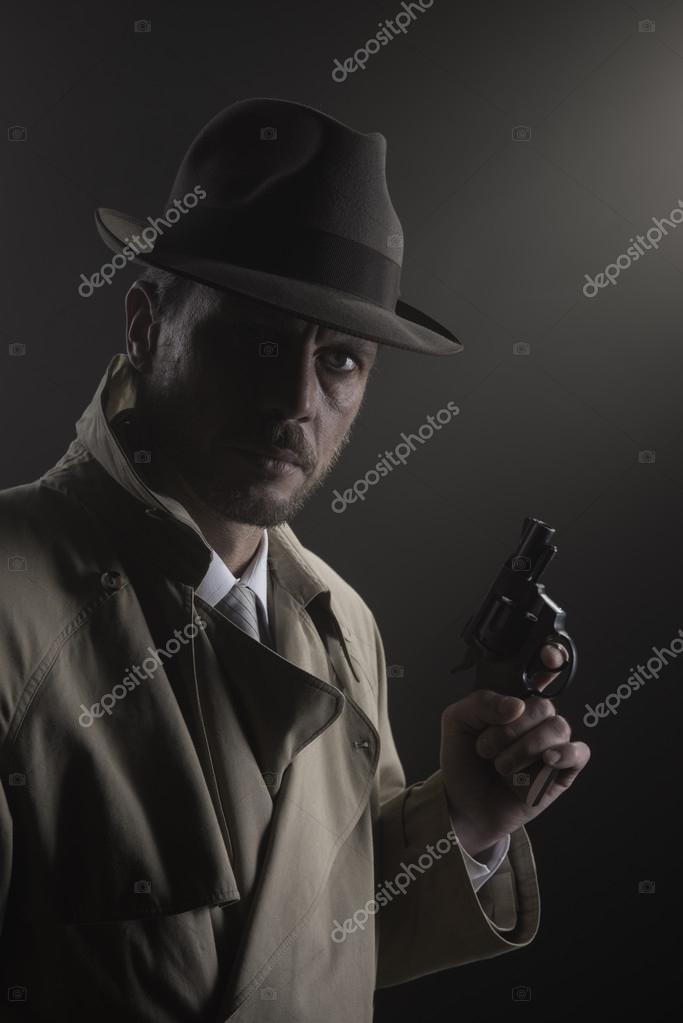 Detective in trench coat holding a gun — Stock Photo © stokkete 88226996