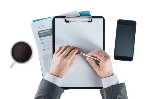 Businessman at desk holding a pen — Stock Photo, Image