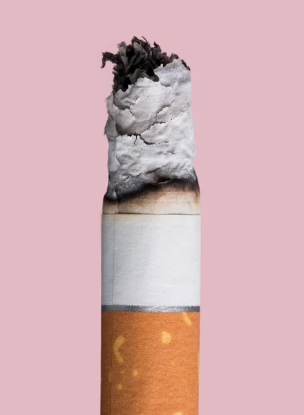 Cigareta hoří na růžovém pozadí — Stock fotografie