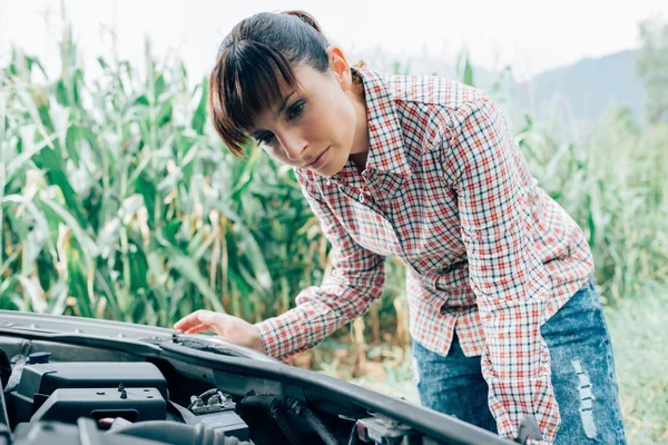 Femme essayant de réparer sa voiture cassée — Photo