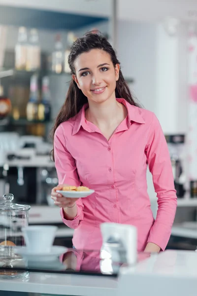 Młody barista serwowania ciasteczek — Zdjęcie stockowe