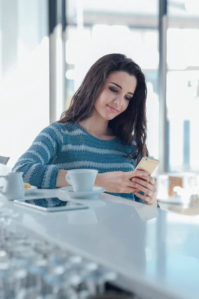 Flicka med mobiltelefon sitter — Stockfoto