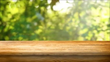 Empty wooden table with fresh green defocused background