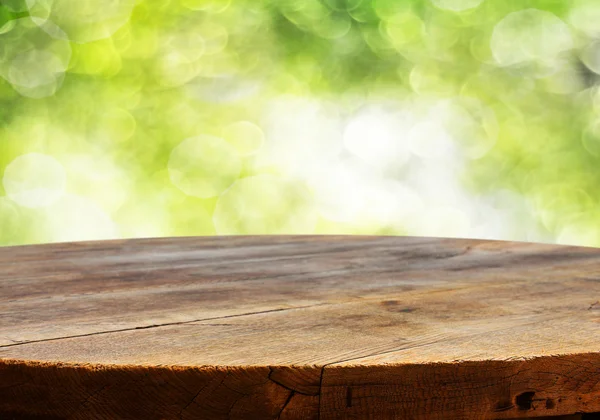 Leerer Tisch mit verschwommenem grünem Hintergrund — Stockfoto