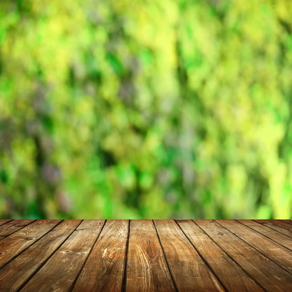 Пустой стол с размытым зеленым фоном — стоковое фото