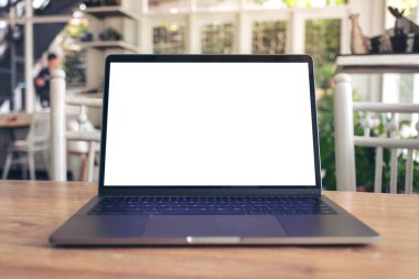 Tahta masadaki boş beyaz masaüstü ekranlı dizüstü bilgisayarın görüntüsü 