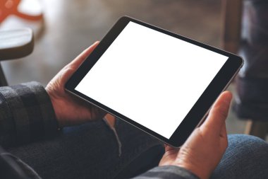 Kafedeki boş ekranlı siyah tableti tutan kadınların ellerinin görüntüsü.