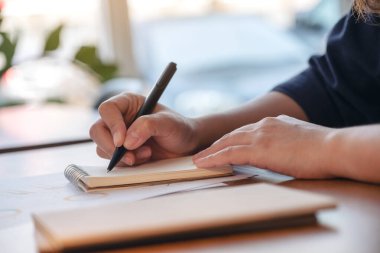 Ahşap masaya boş bir defter üzerine el yazısının yakın plan resmi