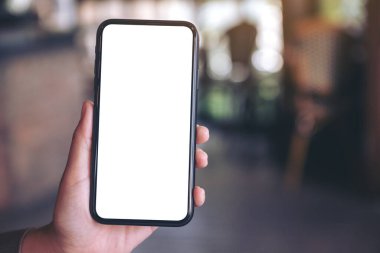 Modern kafede el ele tutuşan ve siyah cep telefonunu beyaz ekranla gösteren bir resim.