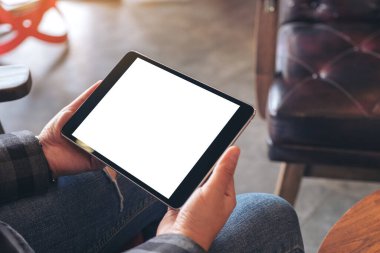 Kafedeki boş ekranlı siyah tableti tutan kadınların ellerinin görüntüsü.