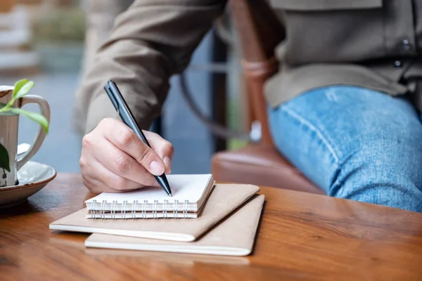 Imagem Close Mão Uma Mulher Escrevendo Caderno Branco Com Xícara — Fotografia de Stock