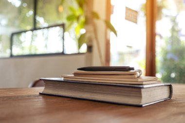 Tahta masadaki kitaplar ve defterler.