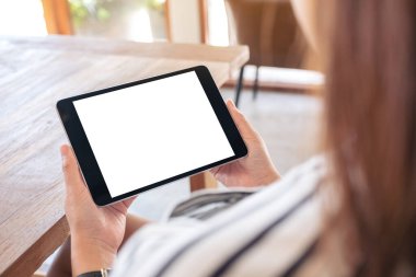 Boş beyaz masaüstü ekran yatay olarak siyah tableti elinde tutan bir kadının görüntüsü