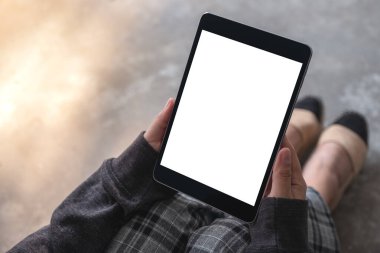  Yerde otururken, beyaz ekranlı siyah tablet bilgisayar kullanan ve el ele tutuşan kadınların görüntülerini taklit et 