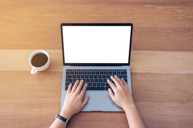 Üst görünümde, ofis masasında boş beyaz masaüstü ekran kullanan ve yazan bir kadının görüntüsü var.