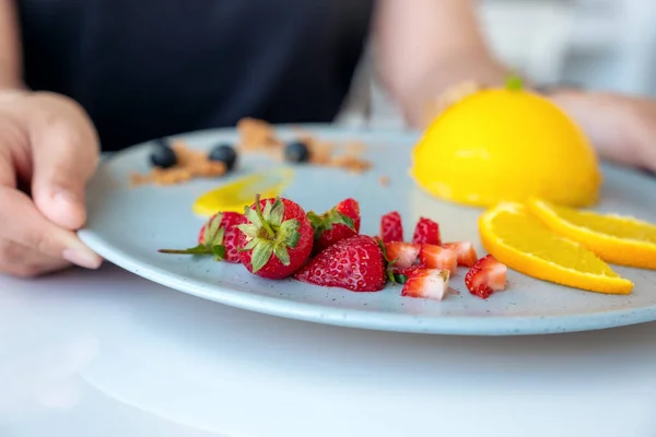 Eine Frau Hält Café Einen Teller Orangenkuchen Mit Gemischten Früchten — Stockfoto