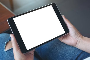 Boş beyaz masaüstü ekran yatay olarak siyah tableti elinde tutan bir kadının görüntüsü