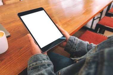 Boş beyaz masaüstü ekran ile siyah tablet bilgisayarını tutan bir kadının görüntüsü 