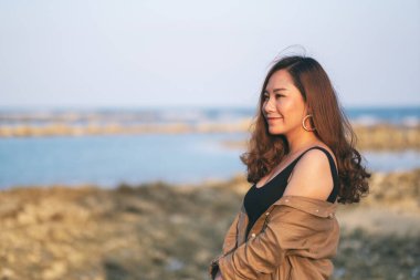 Sahilde yürüyen güzel bir Asyalı kadın.