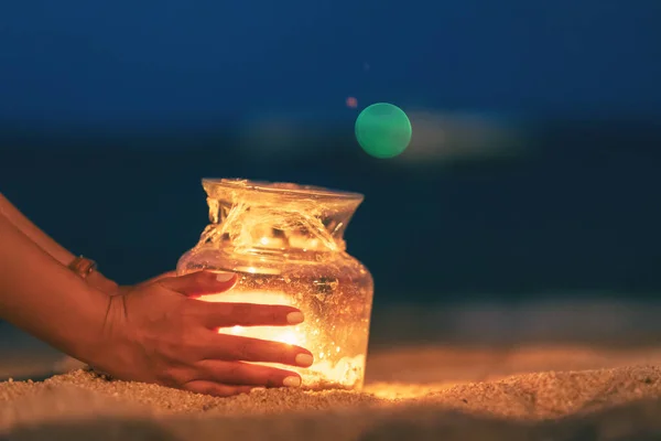 여성이 해변에 유리병 촛불을 모습을 클로즈업 — 스톡 사진