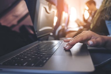 Kulübede otururken dizüstü bilgisayarın dokunmatik dokunuşunu kullanan bir kadının yakın plan görüntüsü.