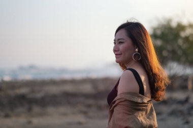 Sahilde yürüyen güzel bir Asyalı kadın.