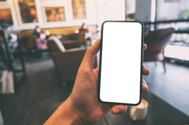 Bir el ele tutuşmanın ve kafede boş beyaz ekranlı siyah cep telefonunu göstermenin maketi.