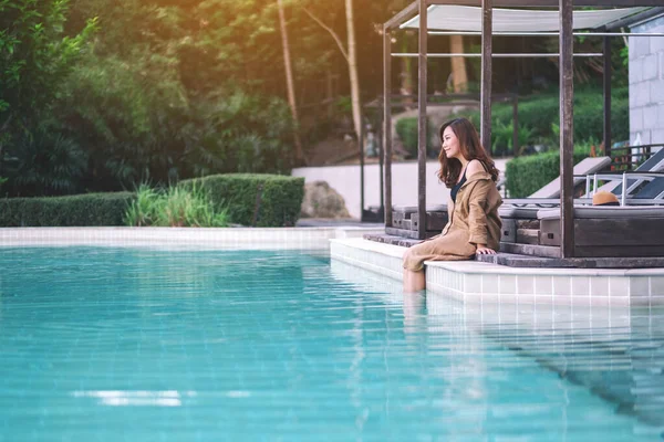 一个美丽的亚洲女人坐在游泳池边的画像 — 图库照片