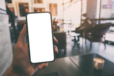 Bir el ele tutuşmanın ve kafede boş beyaz ekranlı siyah cep telefonunu göstermenin maketi.