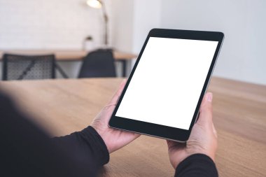 Ofiste otururken siyah tableti beyaz ekranla tutarken ve ona bakarken görüntüyü taklit et