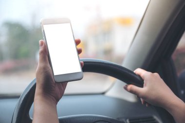 Bir el ele tutuşmanın ve yolda araba sürerken boş masaüstü ekran ile beyaz cep telefonu kullanmanın görüntüsü