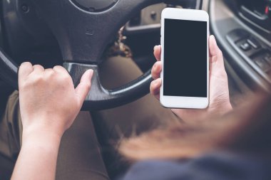 Bir el ele tutuşmanın ve yolda araba sürerken boş siyah masaüstü ekran ile beyaz cep telefonu kullanmanın görüntüsü