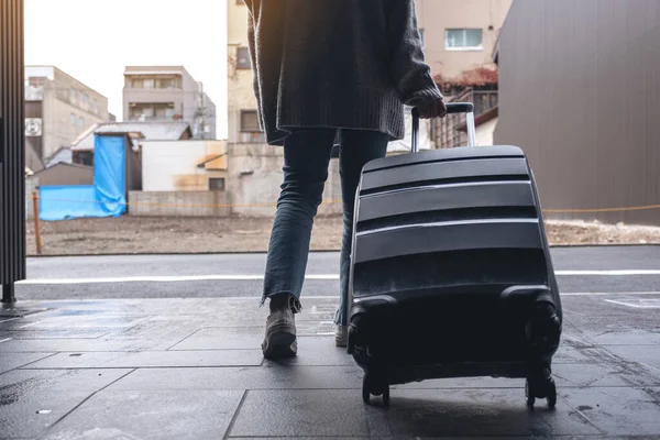 Bir Kadının Gezerken Dışarıda Siyah Bir Bavulu Sürüklerken Görüntüsü — Stok fotoğraf