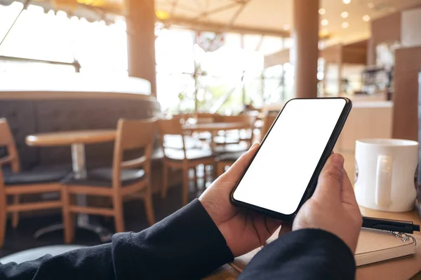 Макет Руки Тримає Чорний Мобільний Телефон Порожнім Білим Екраном Кафе — стокове фото