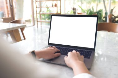 Modern cafe 'de boş beyaz masaüstü ekran kullanan ve yazı yazan el resmi