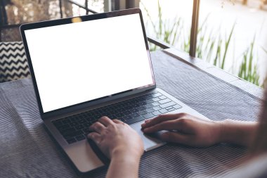 Kafe 'deki boş beyaz masaüstü ekran kullanan ve laptopa dokunan ellerin görüntüsü