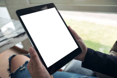 Boş beyaz masaüstü ekranlı siyah tableti tutan ellerin görüntüsü 